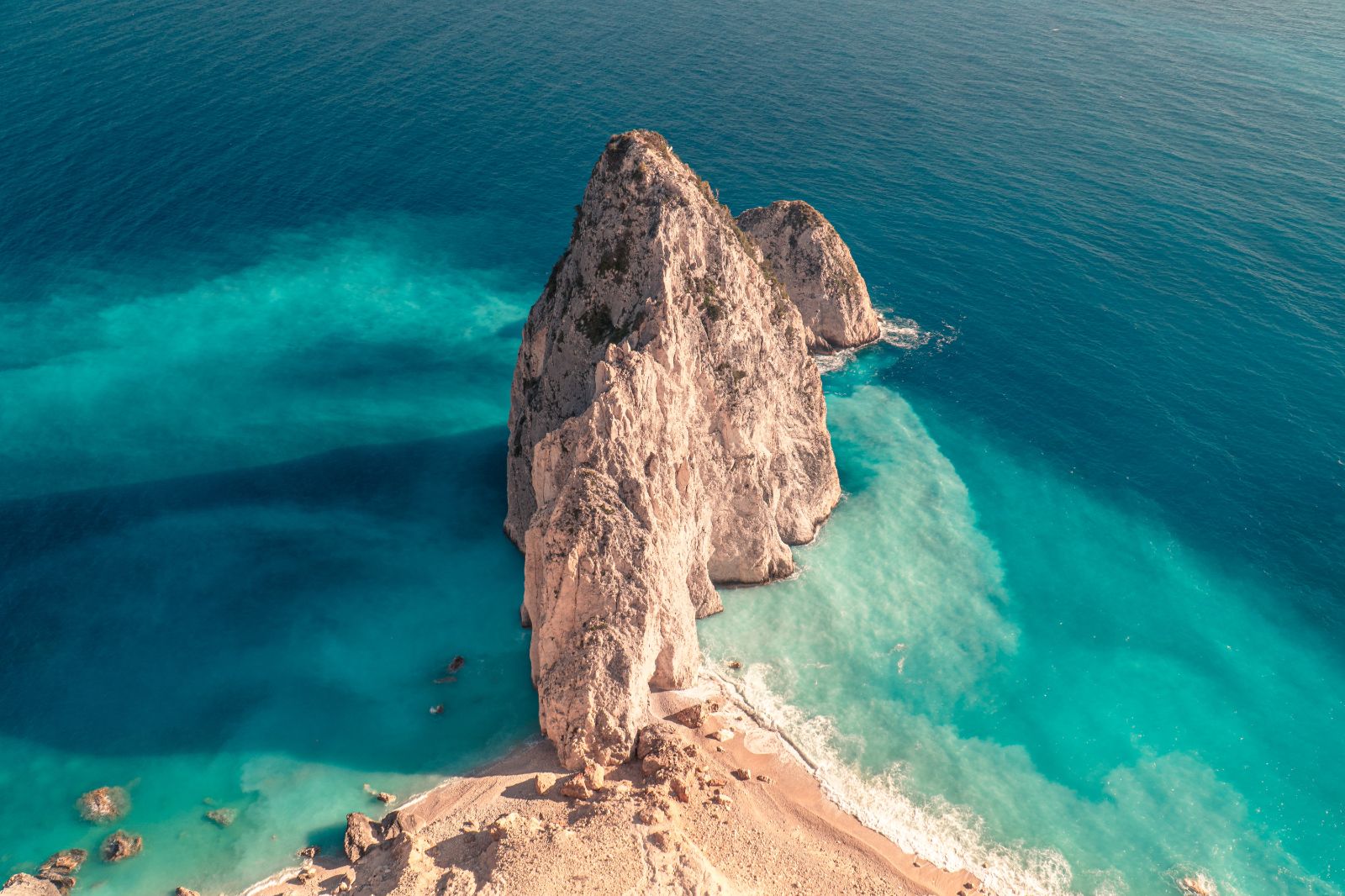 Turquoise waters and rocky outcrop on the Mykonos coastline in Greece