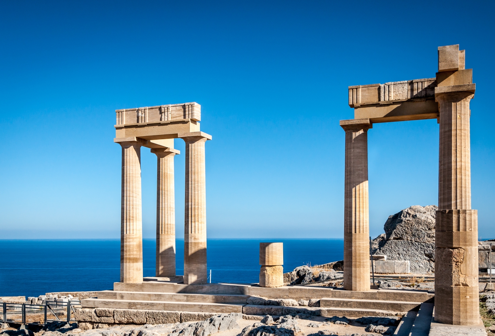 Two sets of columns on a island with the view of the sea