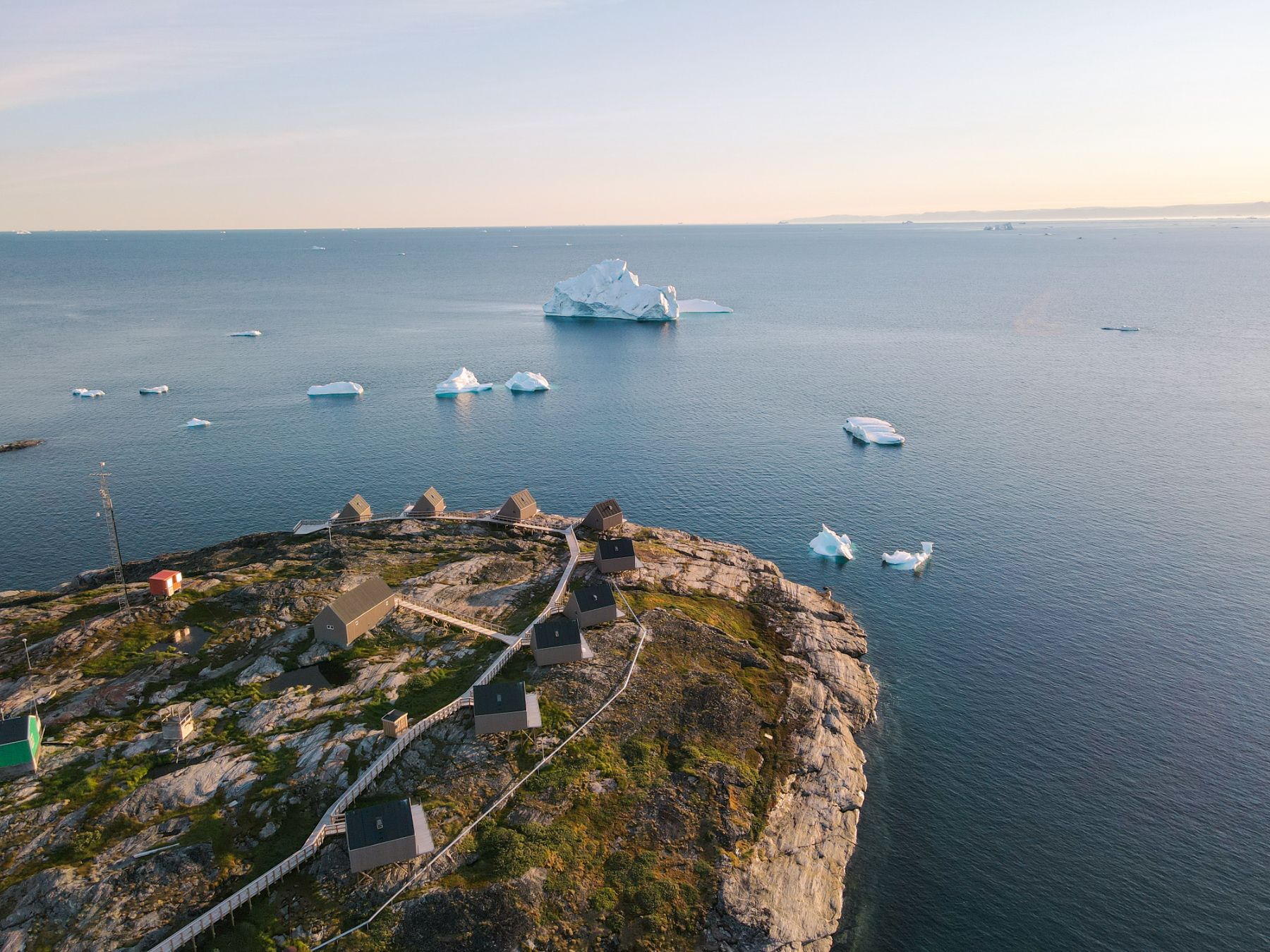 Aerial view of Ilimanaq Lodge in Greenland with an outlook of icebergs in Disko Bay