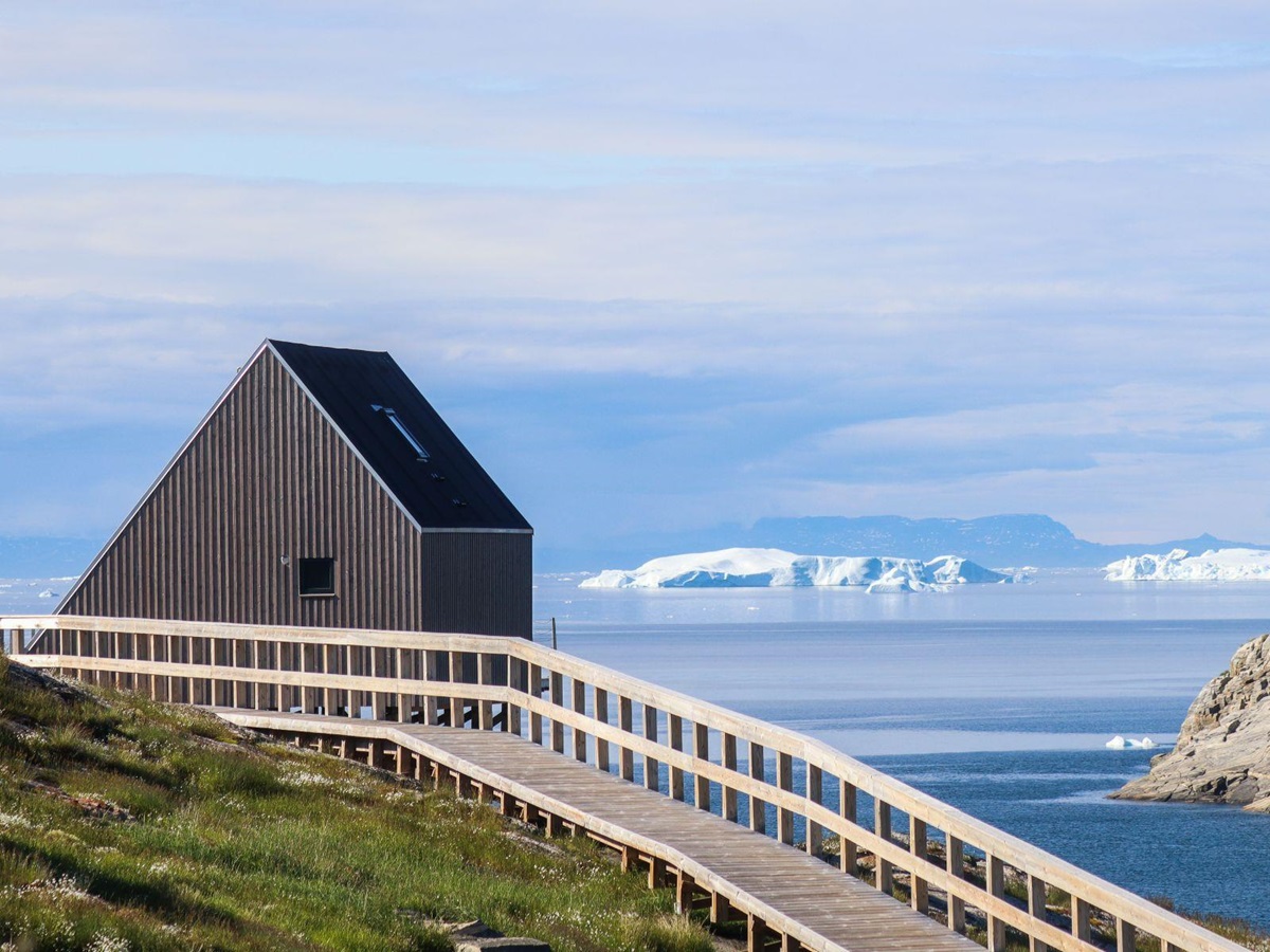 Boardwalk and bungalow at Ilimanaq Lodge Greenland looking out to icebergs in Disko Bay