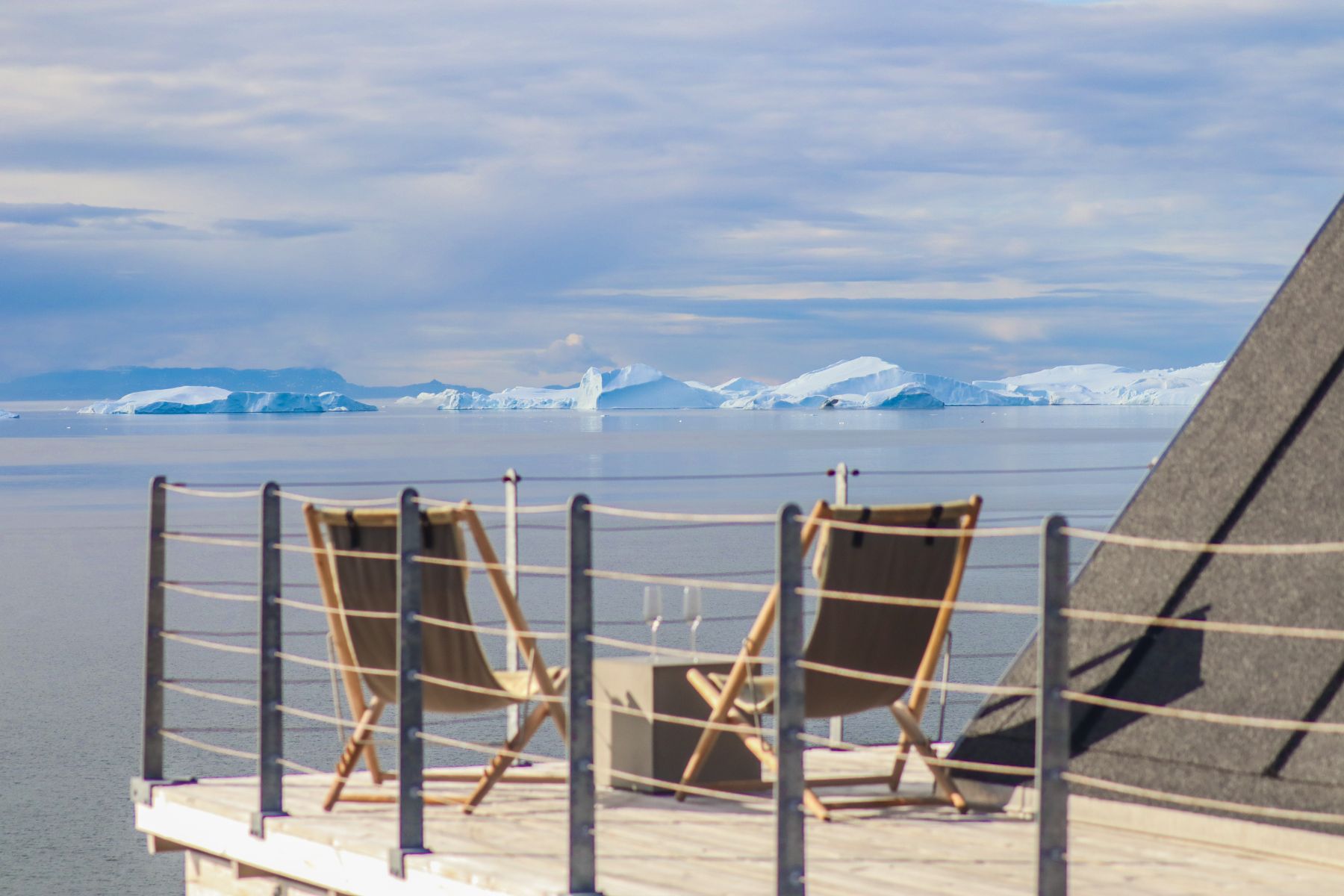 Deckchairs and view of icebergs in Disko Bay from a private terrace at Ilimanaq Lodge Greenland