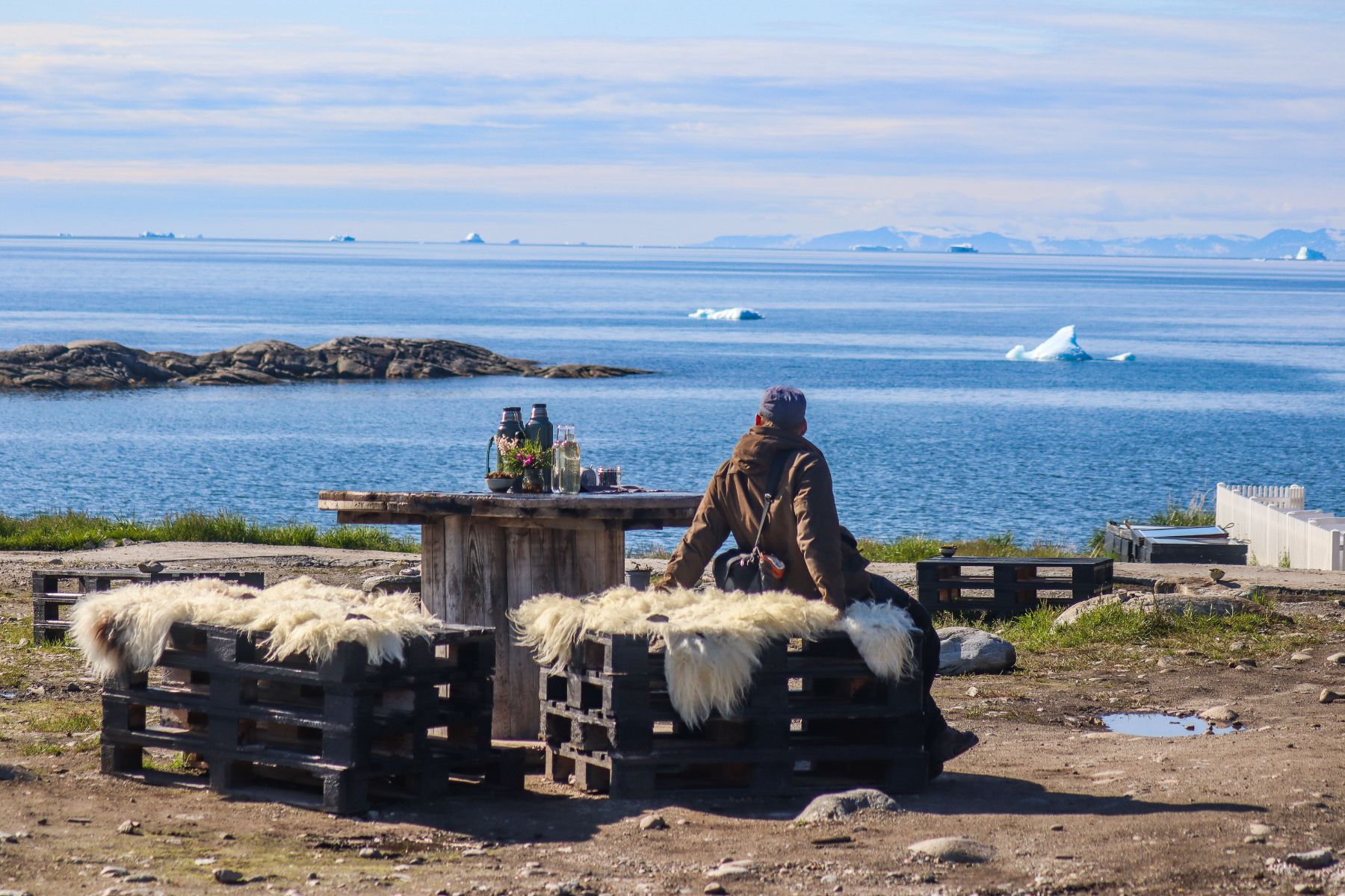 Guest at Ilimanaq Lodge Greenland enjoying outdoor dining and views of Disko Bay