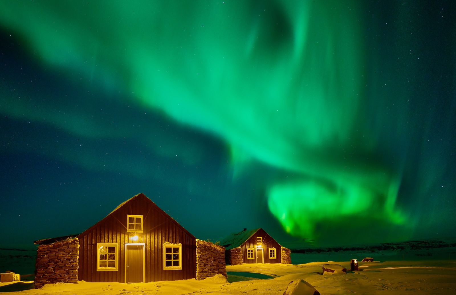 Bright Northern Lights over the Torfhus Retreat hotel in Iceland