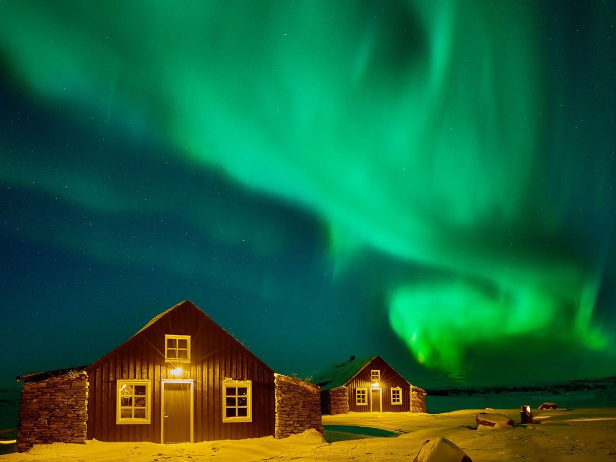 Bright Northern Lights over the Torfhus Retreat hotel in Iceland