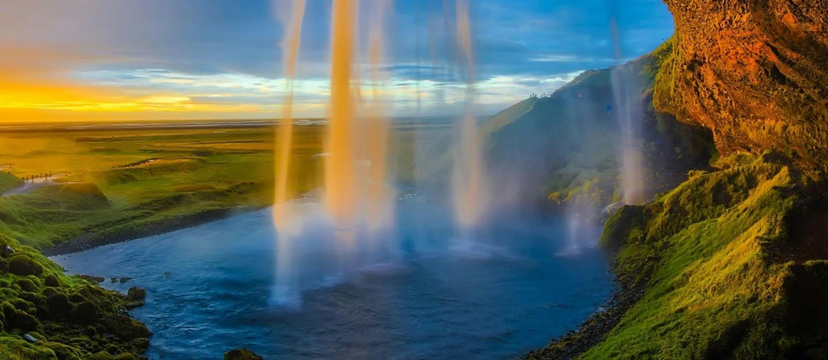 Sunset behind the cascade of the Seljalandsfoss Waterfall in Iceland