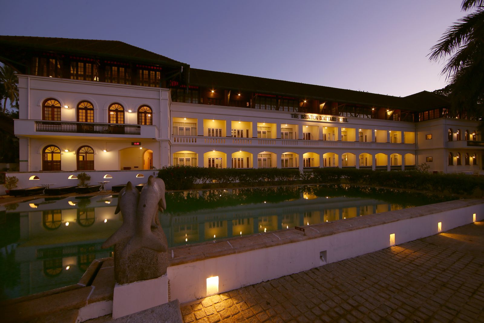The exterior of the Brunton Boatyard hotel India by night