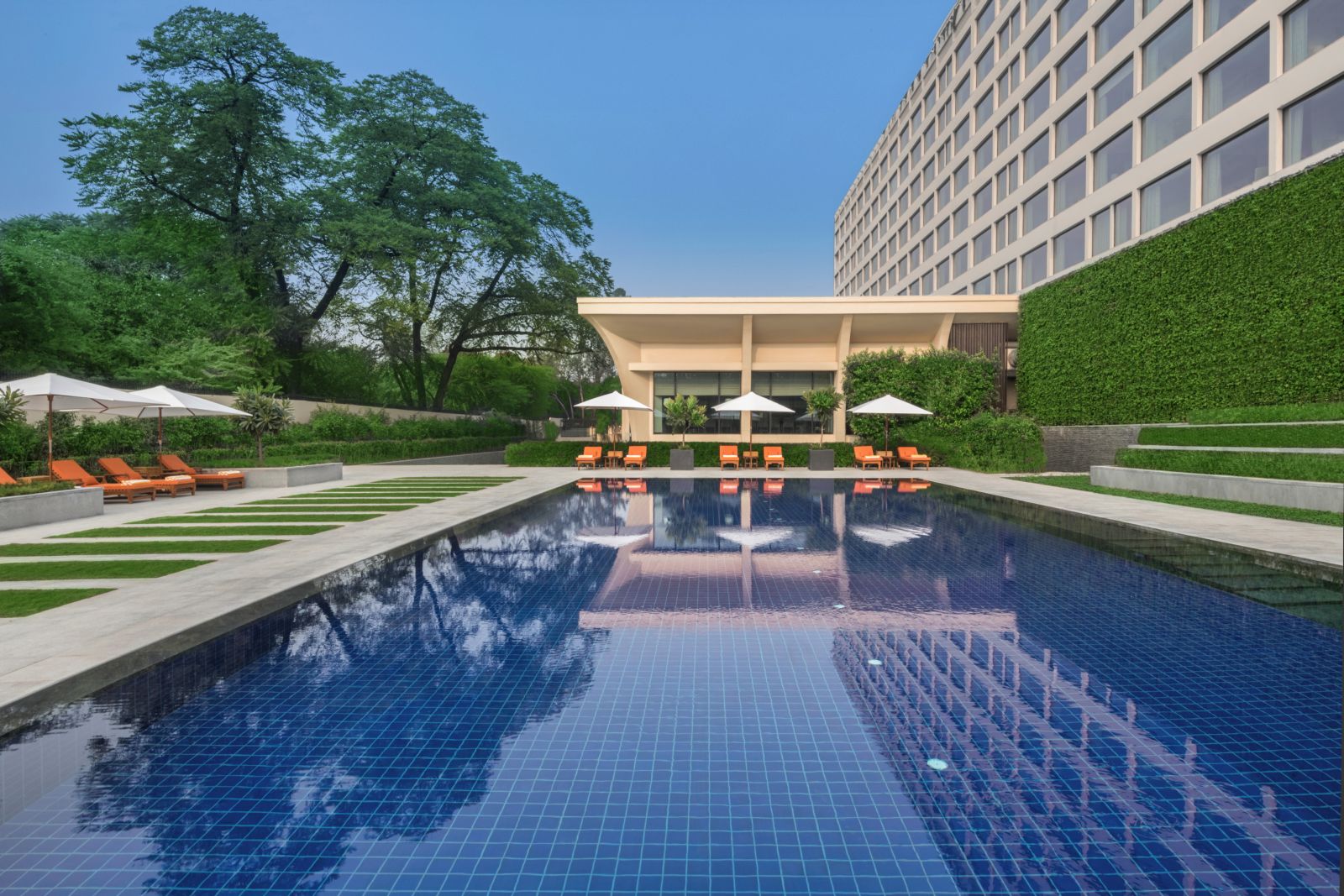 The outdoor swimming pool set in the gardens at the  Oberoi Delhi Hotel in New Dehli