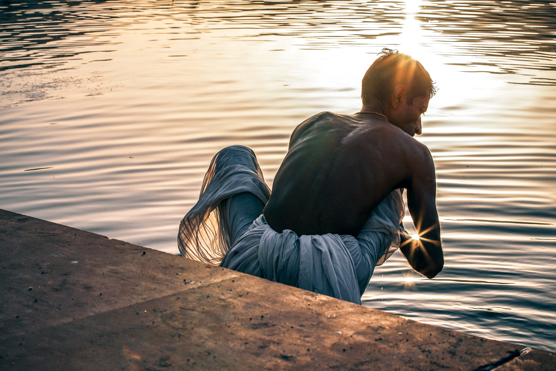 An Indian man cleaning in the river
