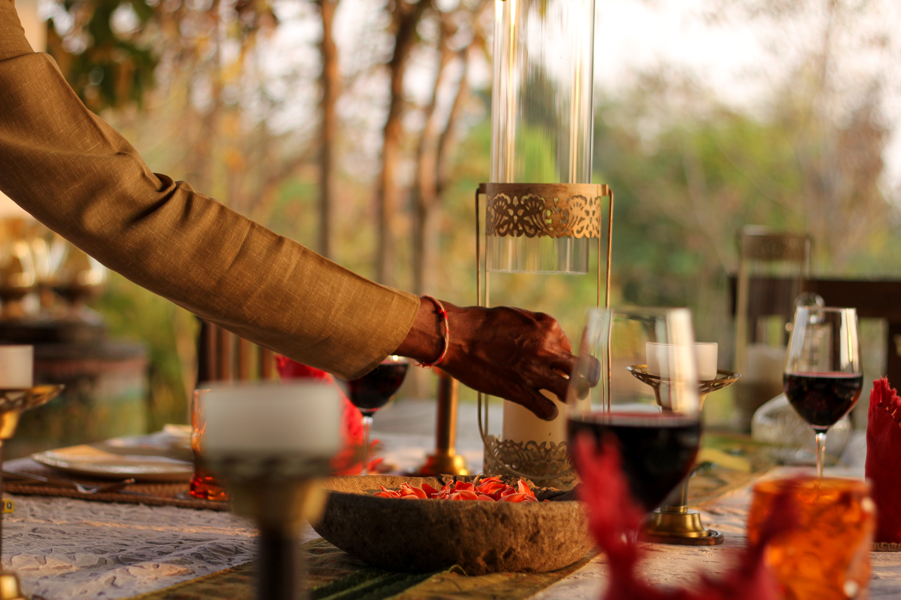 Candles and drinks set up on a dining table at Flame of the Forest in India