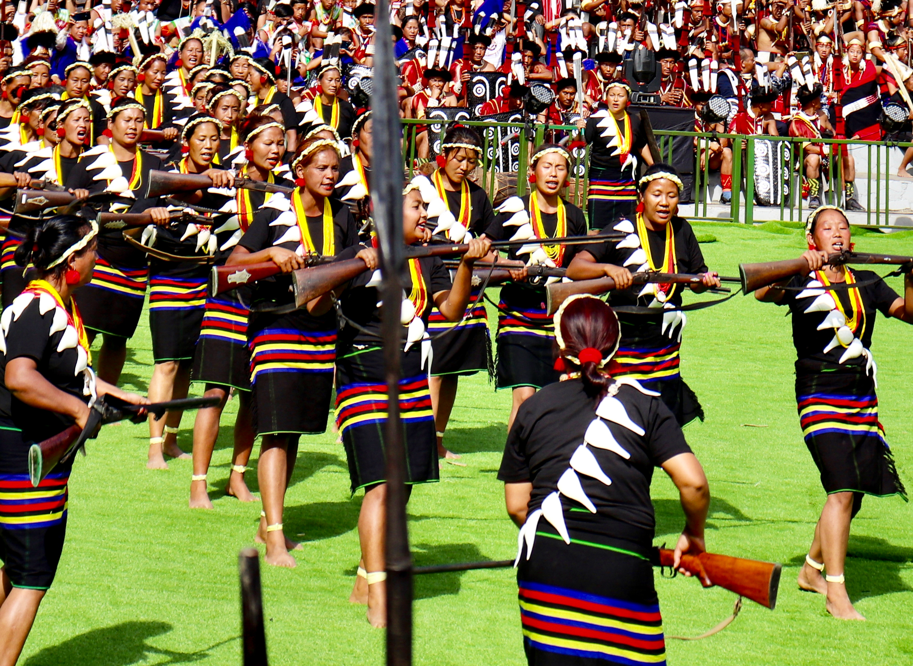 Women dancing with rifles at the Hornbill Festival in Nagaland