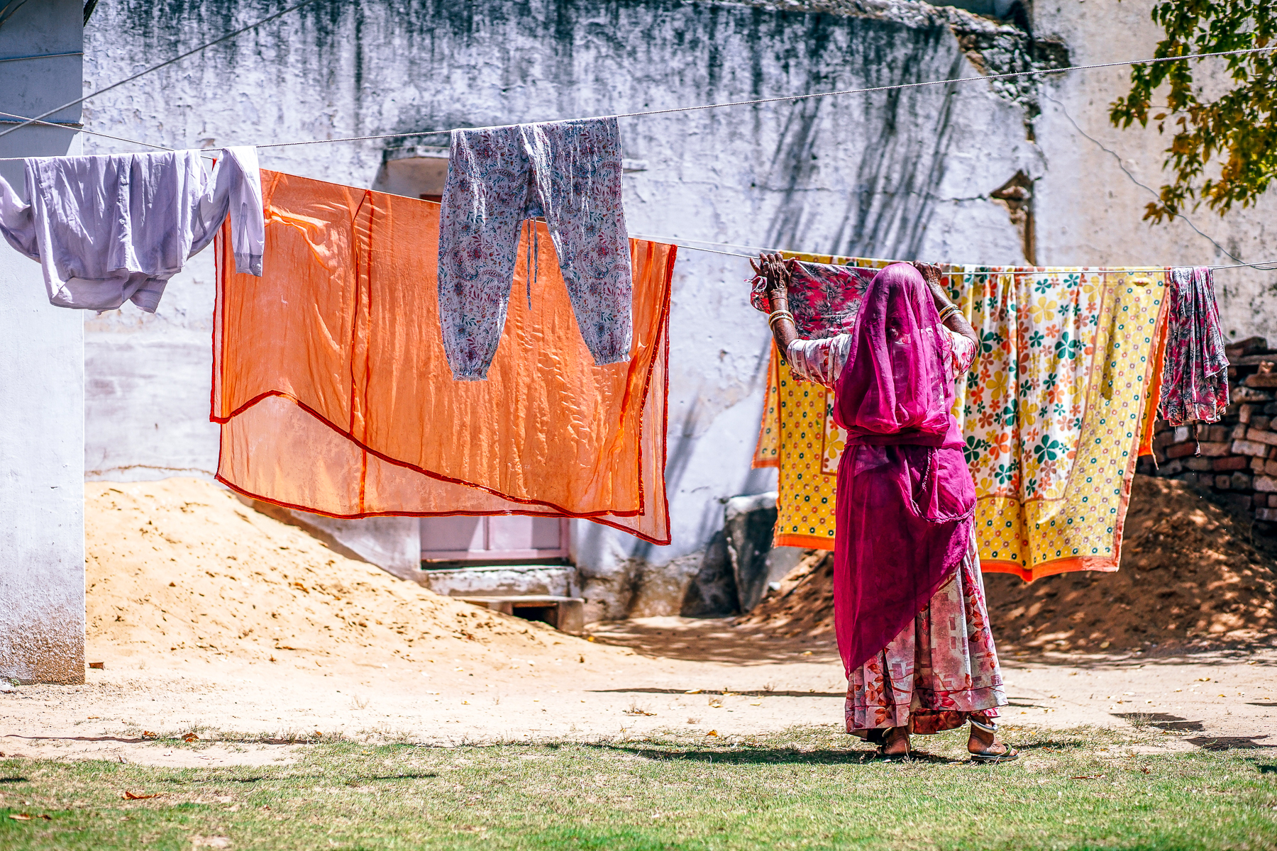 An Indian lady hanging out laundry