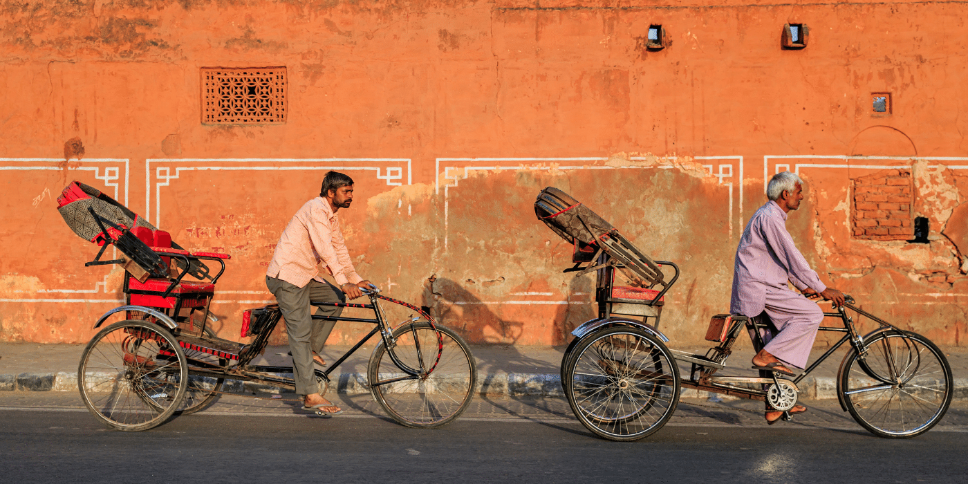 Indian men cycling rickshaws