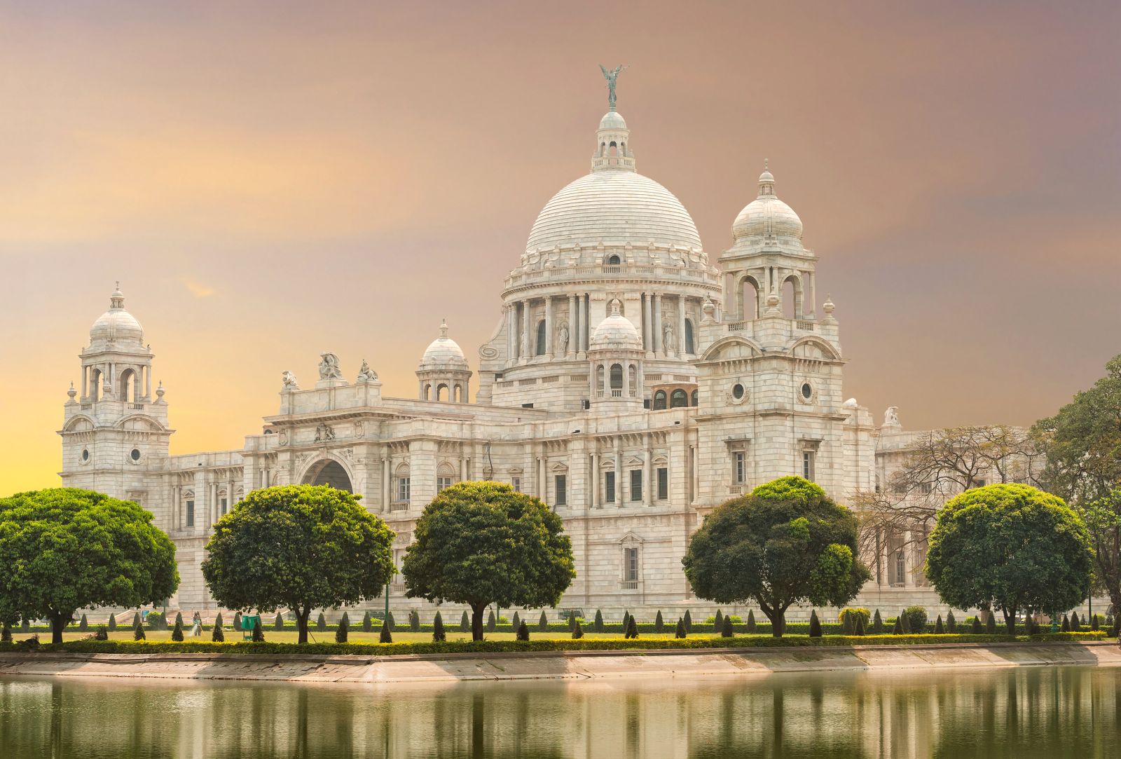The Victoria Memorial, a beautiful white marble building with a domed roof and a river and trees in front, in Kolkata, West Bengal, India
