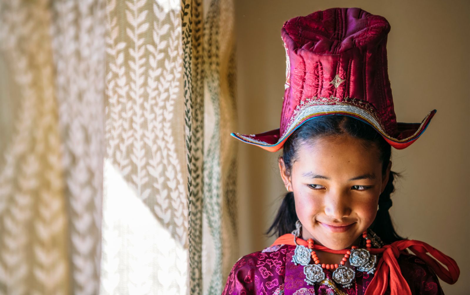 Young girl smiling wearing Tibetan clothing, Ladakh, India