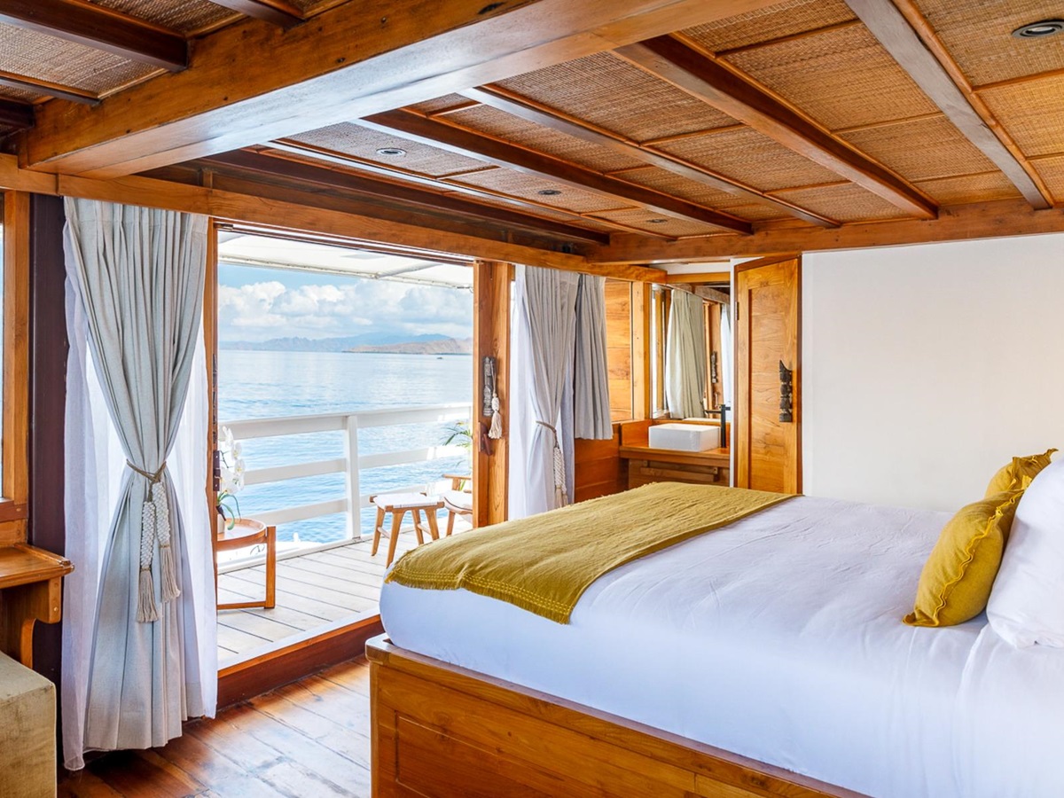 Double bed with views onboard the luxury phinisi Aliikai in Indonesia