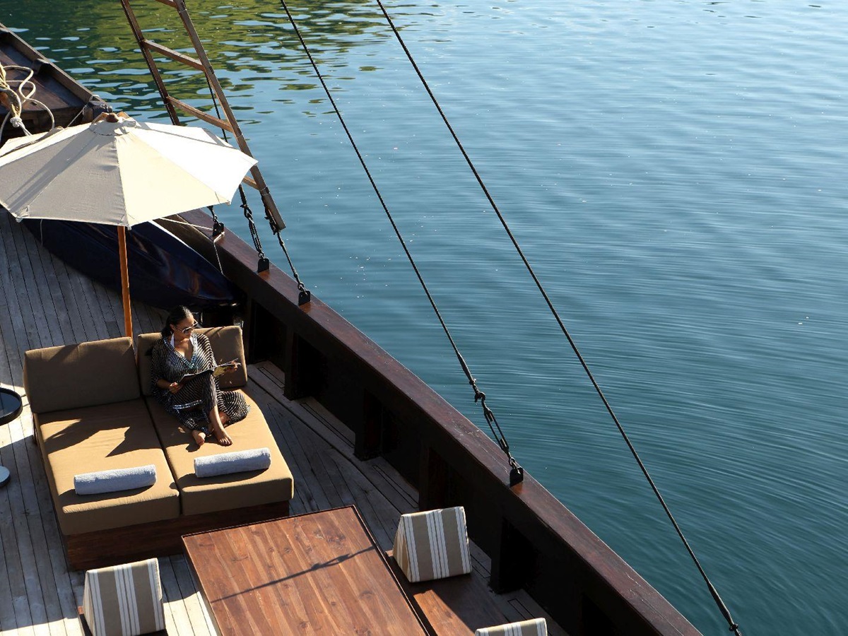 Lady relaxing on a lounger on the deck of the Alila Purnama phinisi in Indonesia