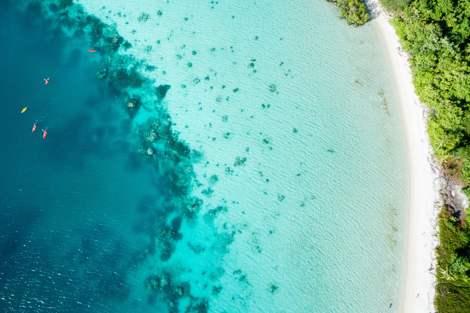 Aerial view of kayakers in turquoise waters at Bawah Reserve Indonesia