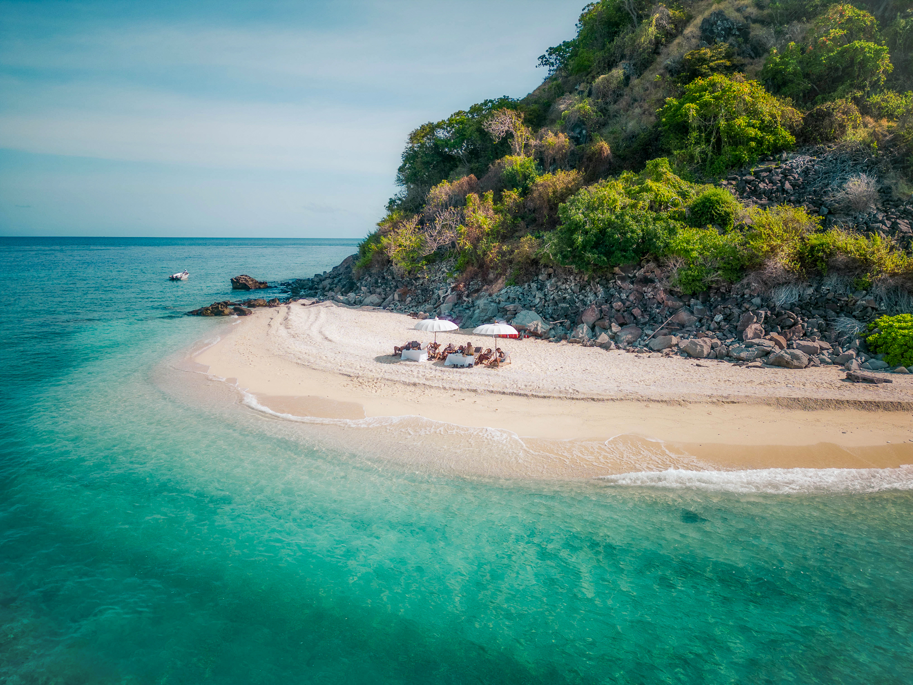 Guests relaxing on the beach from the Fenides luxury phinisi in Indonesia