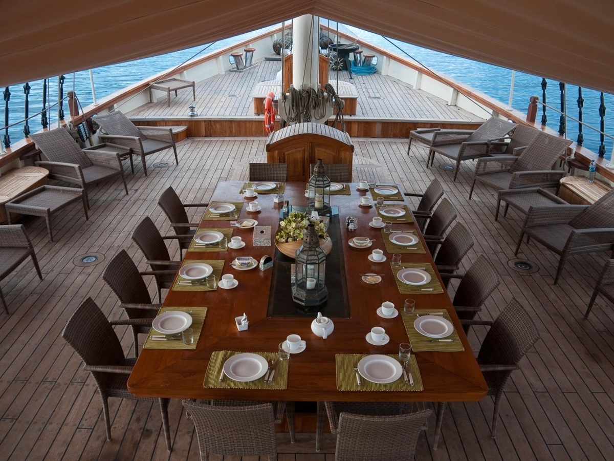 Dining on deck with large table under canvas