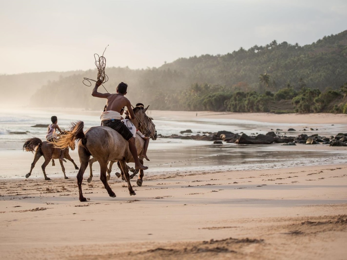 Locals riding subanese stallions on the beach at Nihi Sumba