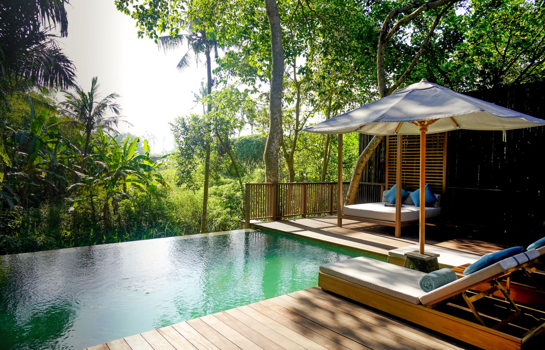 Residence swimming pool and loungers at Nirjhara luxury resort in Bali
