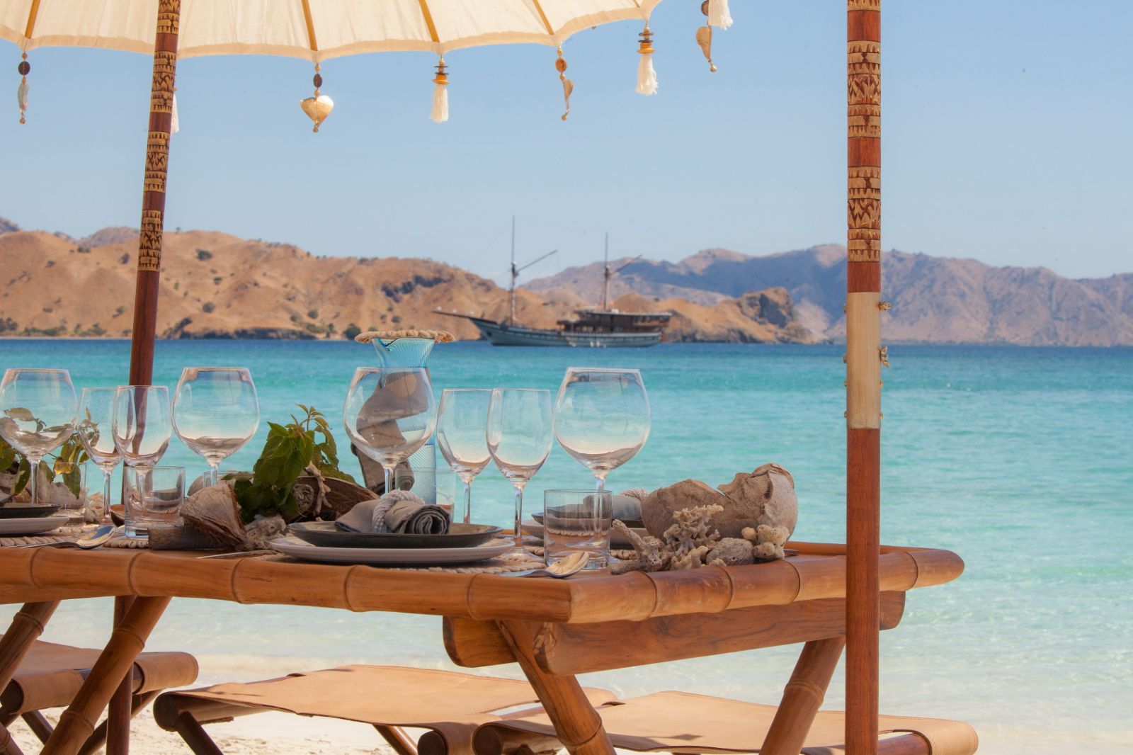 A dining table set up on the beach from the Prana phinisi in Indonesia