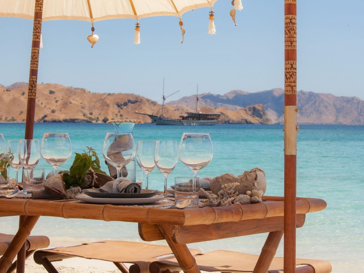 A dining table set up on the beach from the Prana phinisi in Indonesia