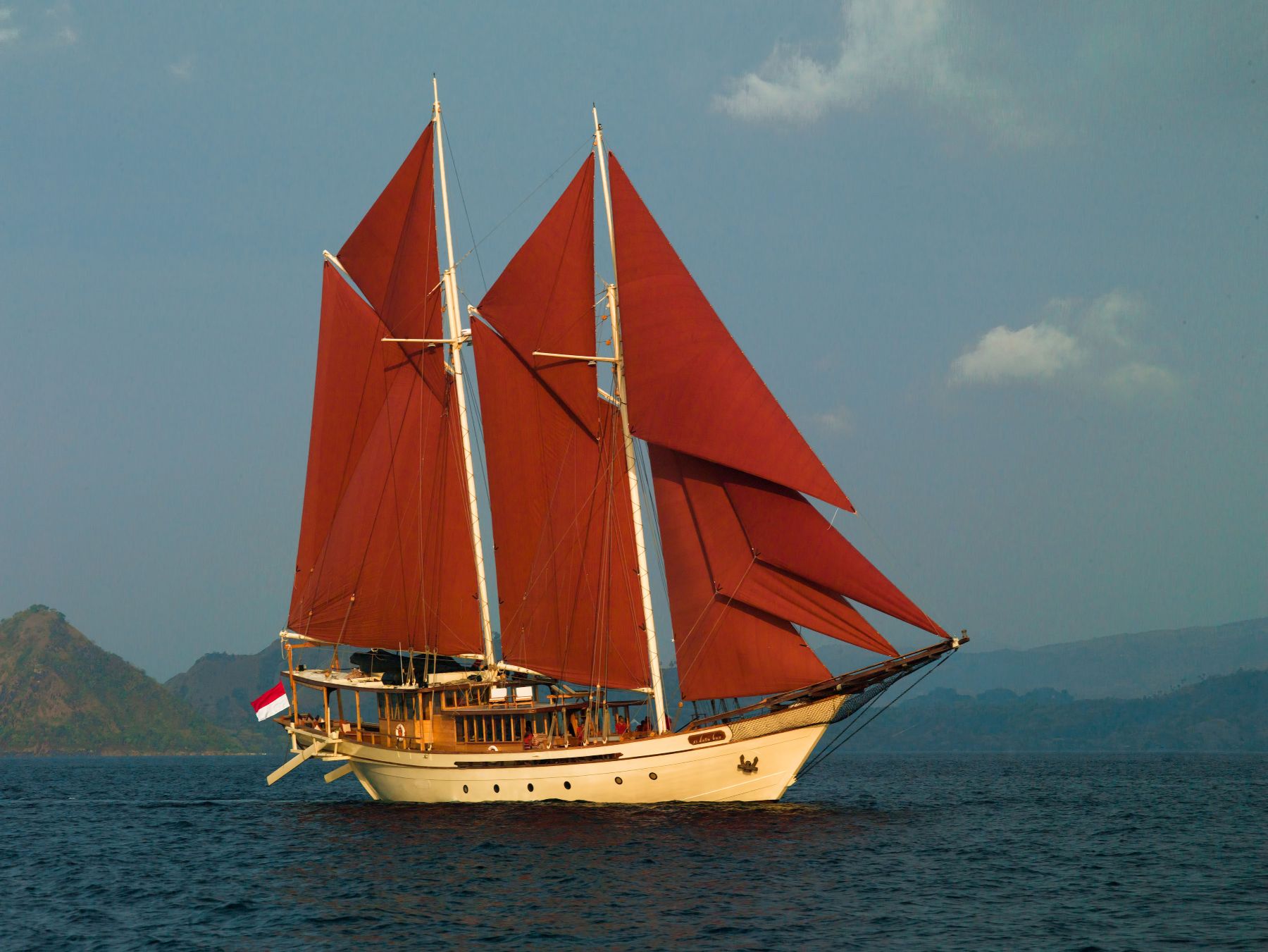 Exterior view of Si Datu Bua luxury phinisi cruising with its sails up