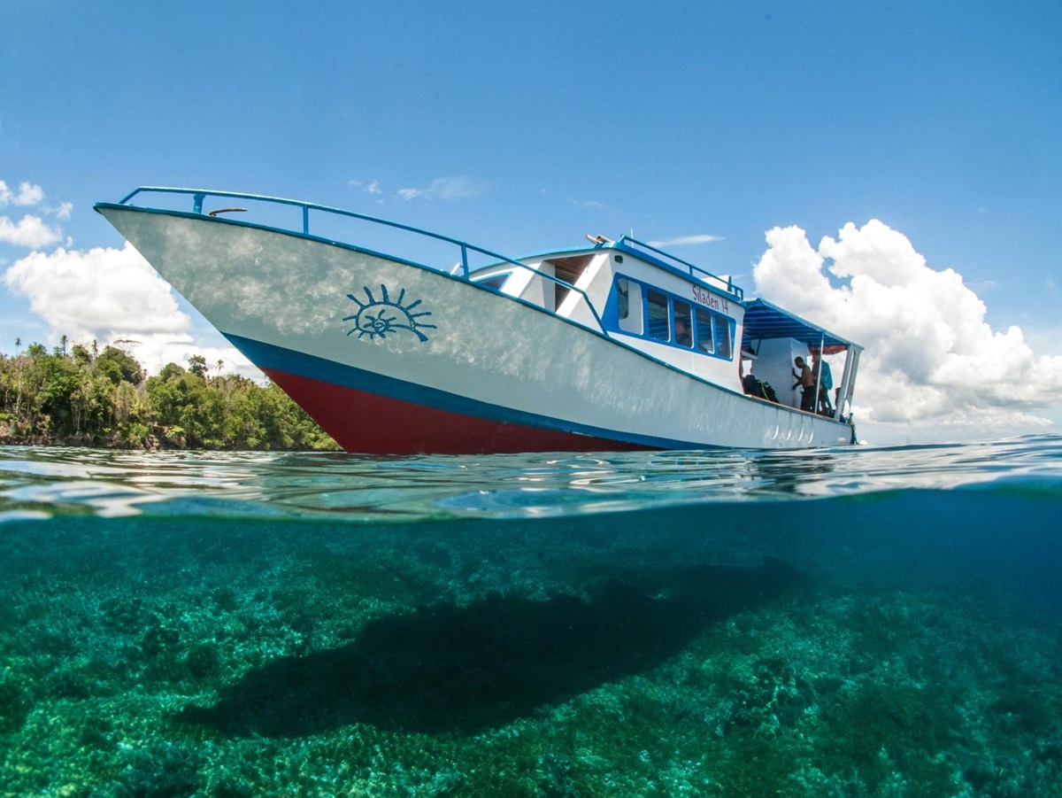 Boat at hotel Siladen in Indonesia and view under with clear blue water