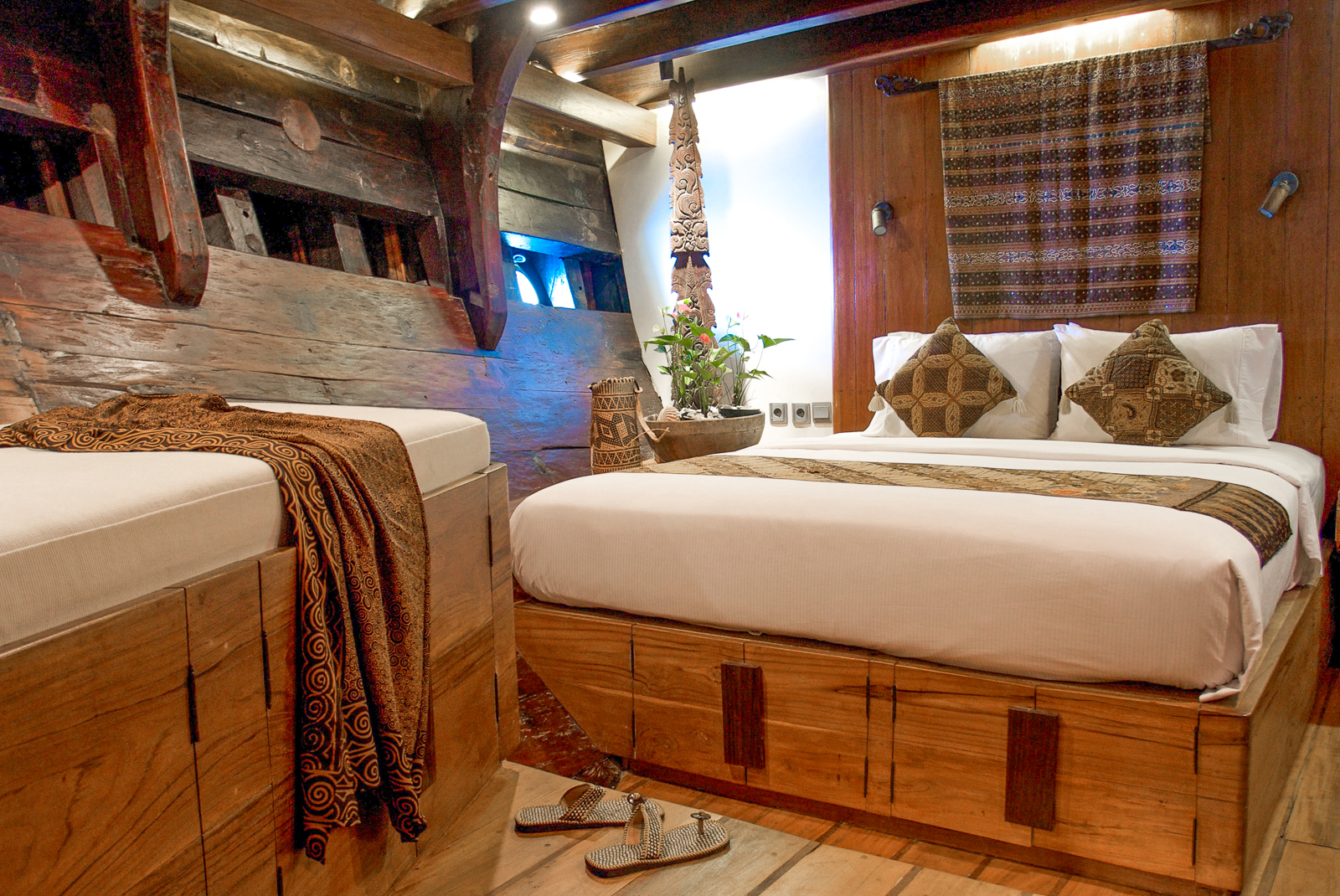 Guest cabin bedroom onboard the Silolona phinisi in Indonesia