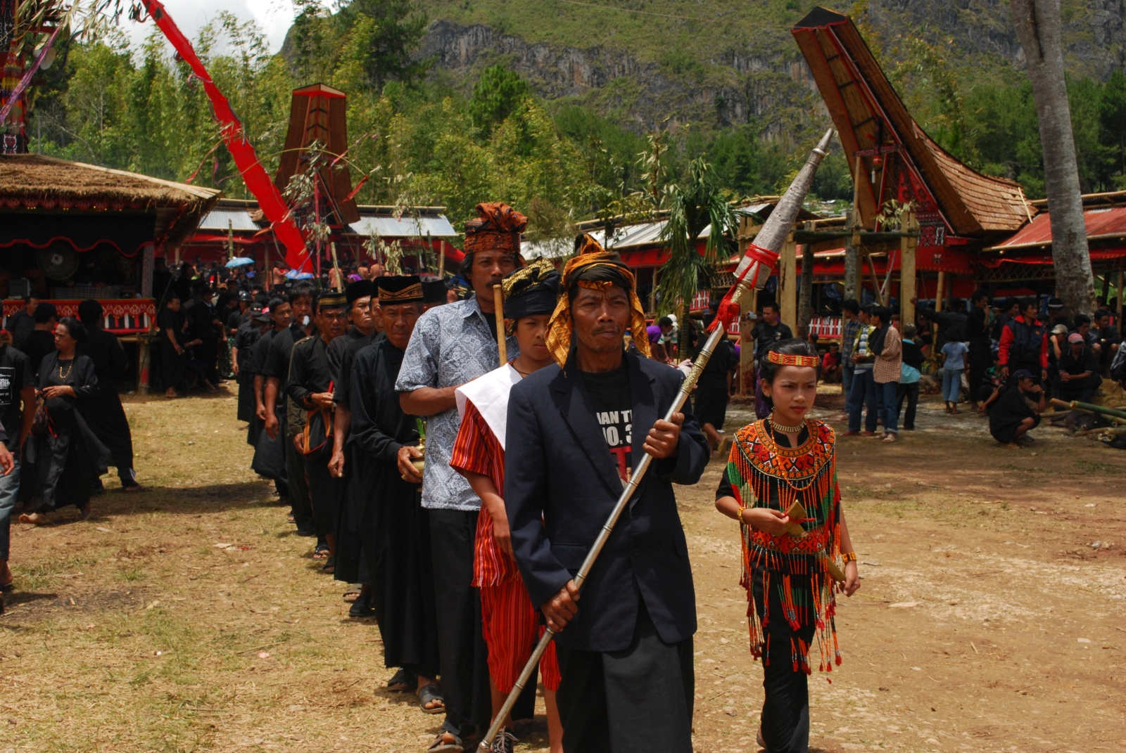 Funeral procession with flags and ceremonial costumes