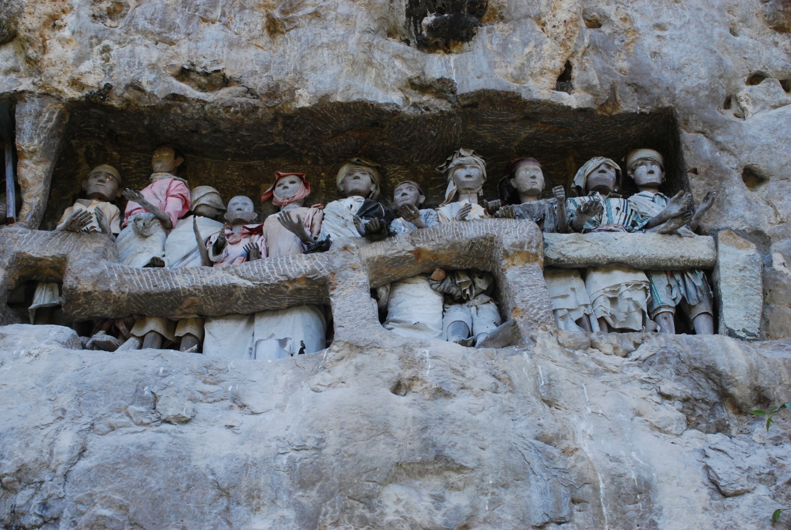 Wooden effigies within a hole in a stone wall