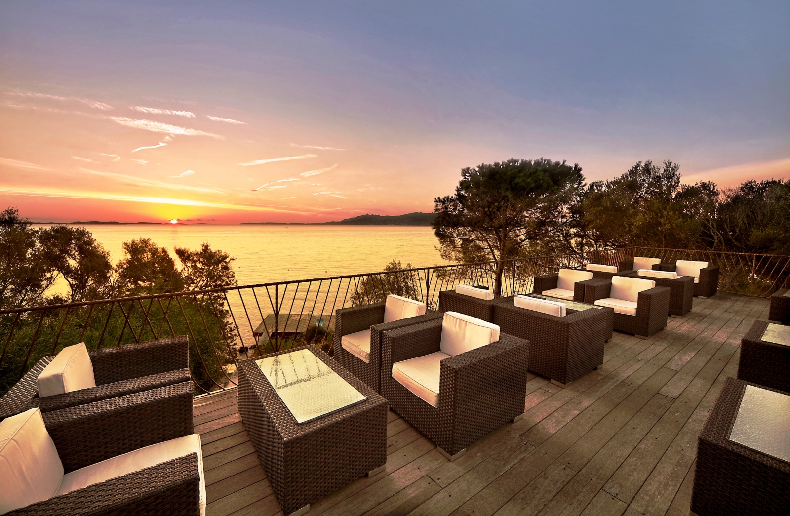Sundowner bar with seating, overlooking sunset over the Mediterranean at luxury hotel Capo d'Orso on Sardinia, Italy
