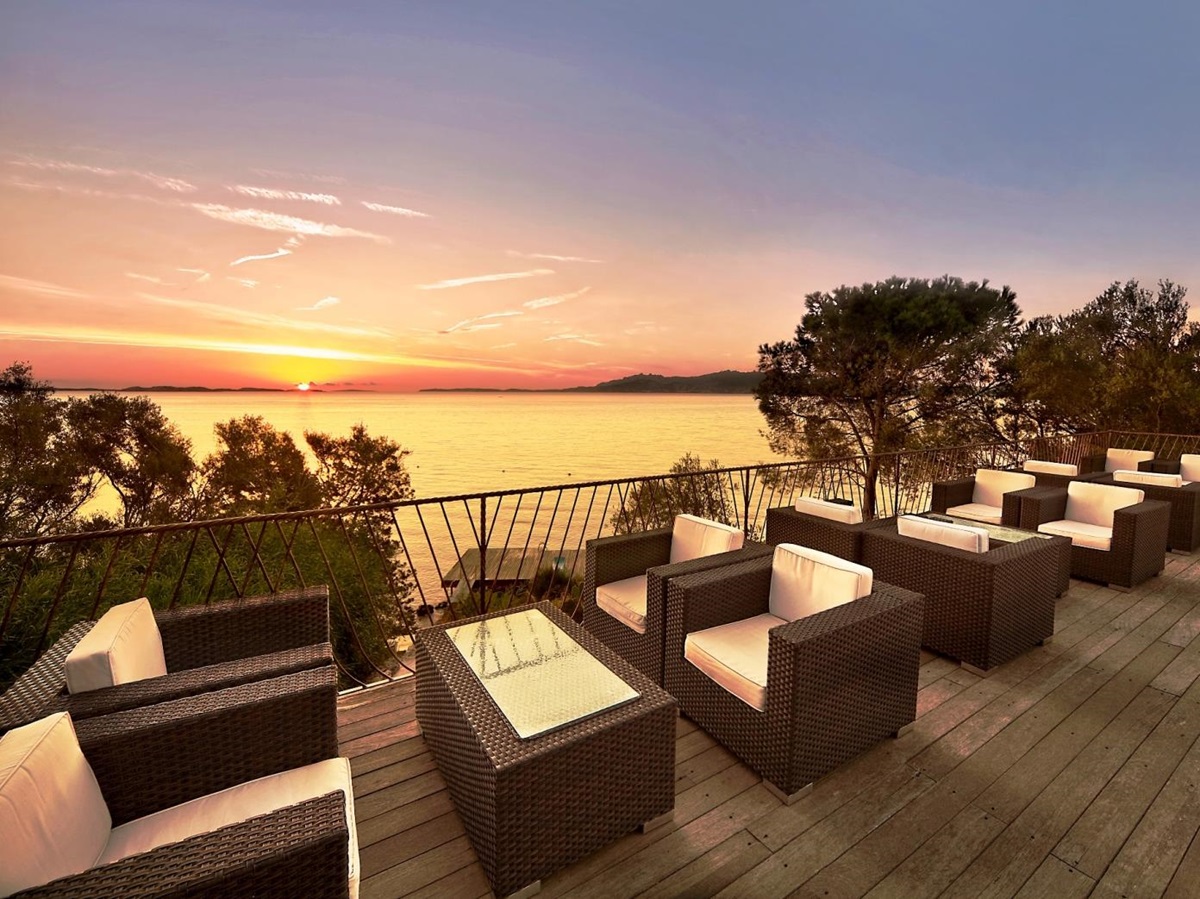 Sundowner bar with seating, overlooking sunset over the Mediterranean at luxury hotel Capo d'Orso on Sardinia, Italy