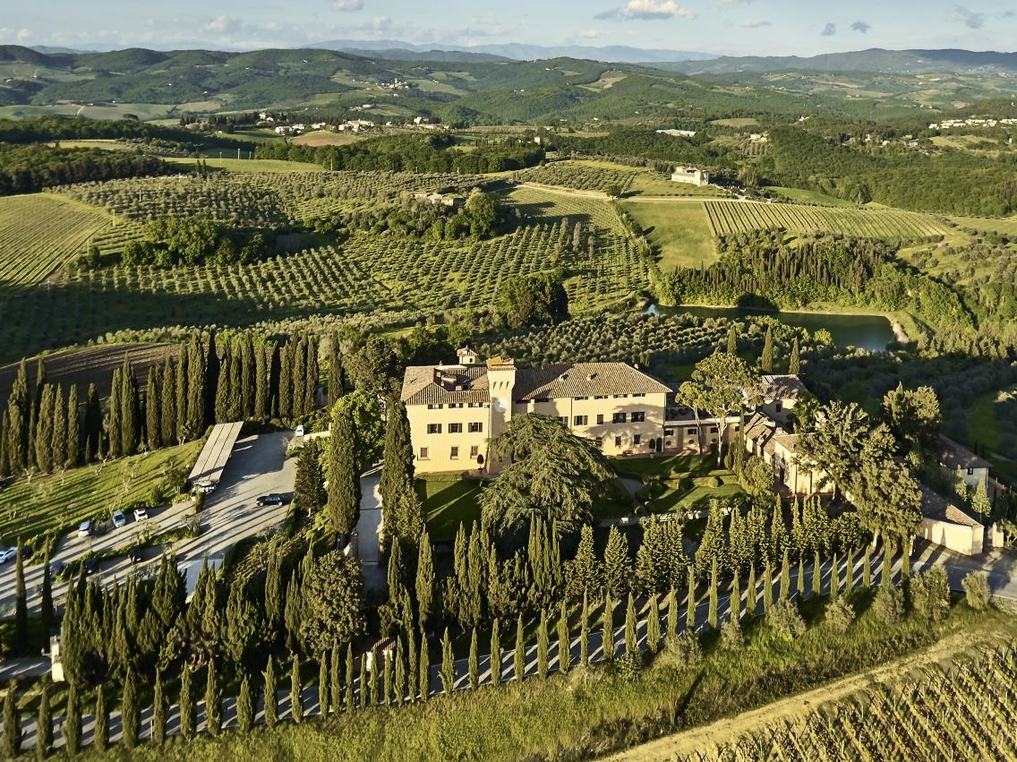 Aerial view over luxury resort COMO Castello del Nero in Italy and surrounding countryside