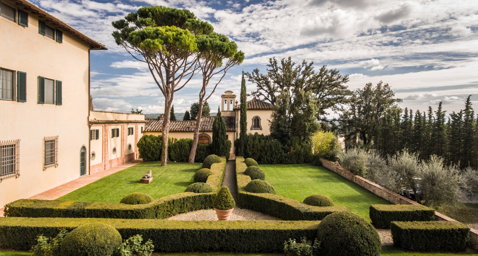 Exterior of the chapel and gardens at luxury resort COMO Castello del Nero in Italy