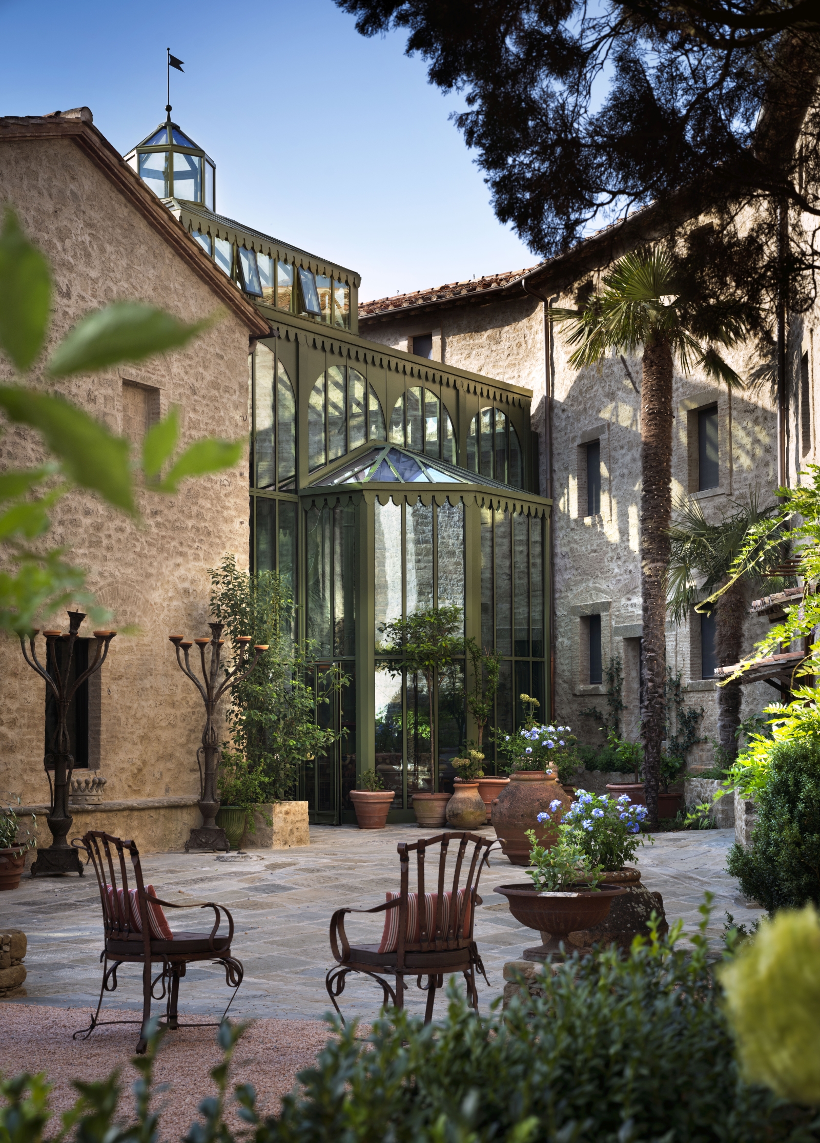 Chairs on a terrace outside the conservatory at luxury hotel Castello di Reschio in Umbria, Italy