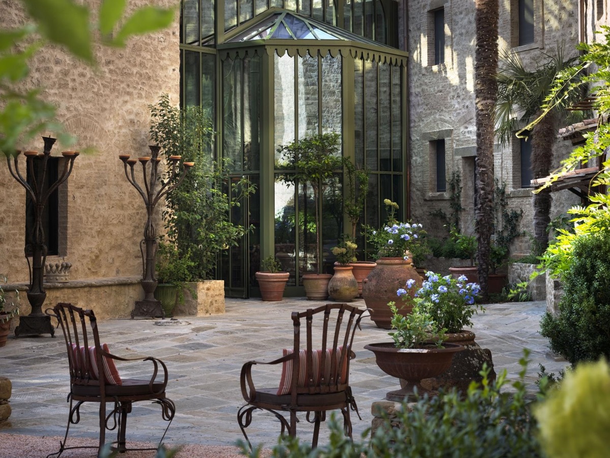 Chairs on a terrace outside the conservatory at luxury hotel Castello di Reschio in Umbria, Italy