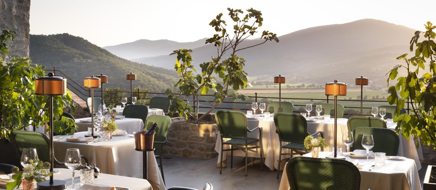 Terrace dining at luxury hotel Castello di Reschio in Italy, with views over the sweeping hills of Umbria