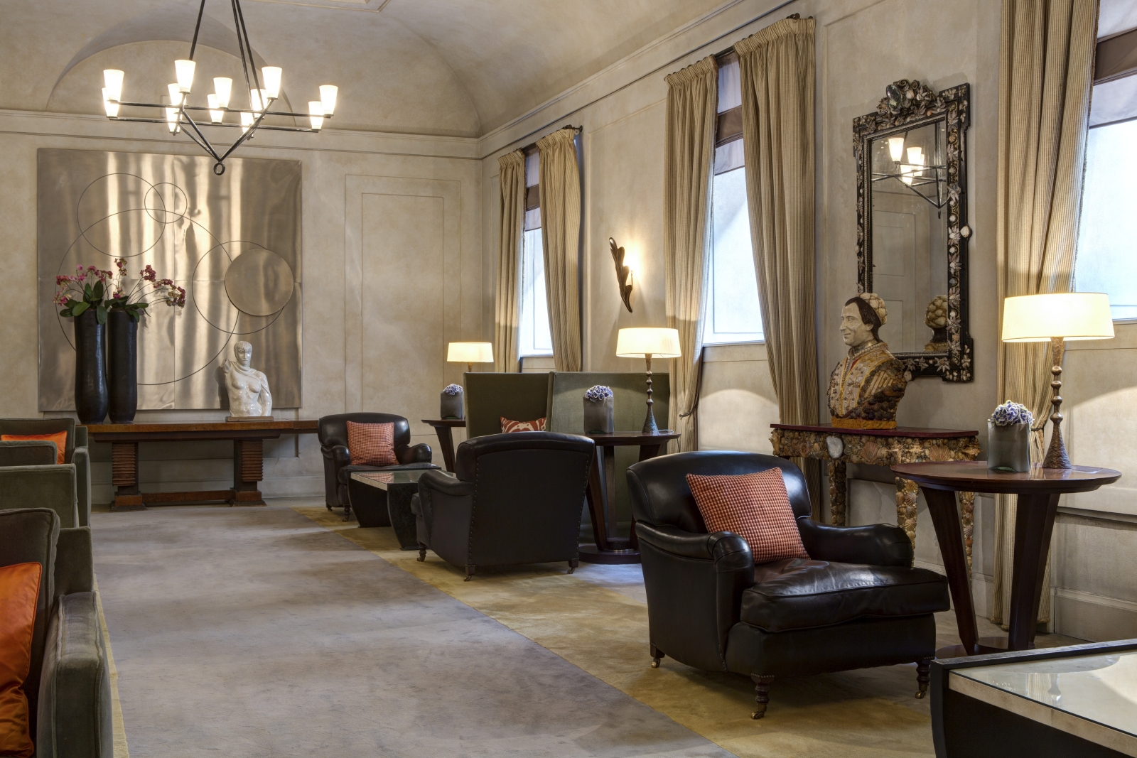 Lobby with wall art, comfortable leather chairs and statues at Hotel de Russie, luxury hotel in Rome, Italy