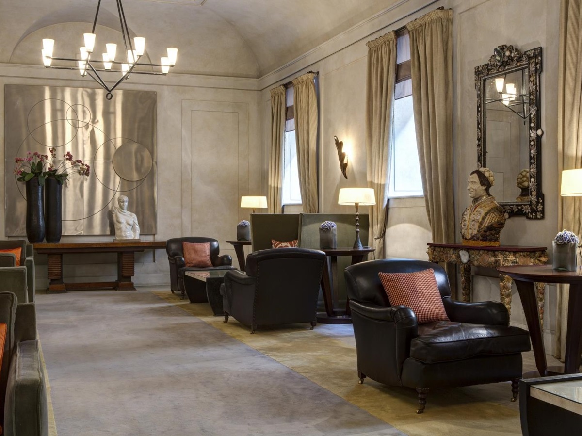 Lobby with wall art, comfortable leather chairs and statues at Hotel de Russie, luxury hotel in Rome, Italy