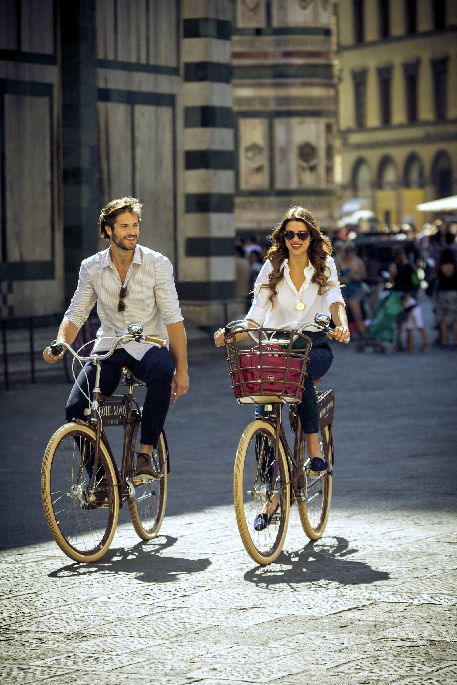 Two people cycling through the streets of Florence