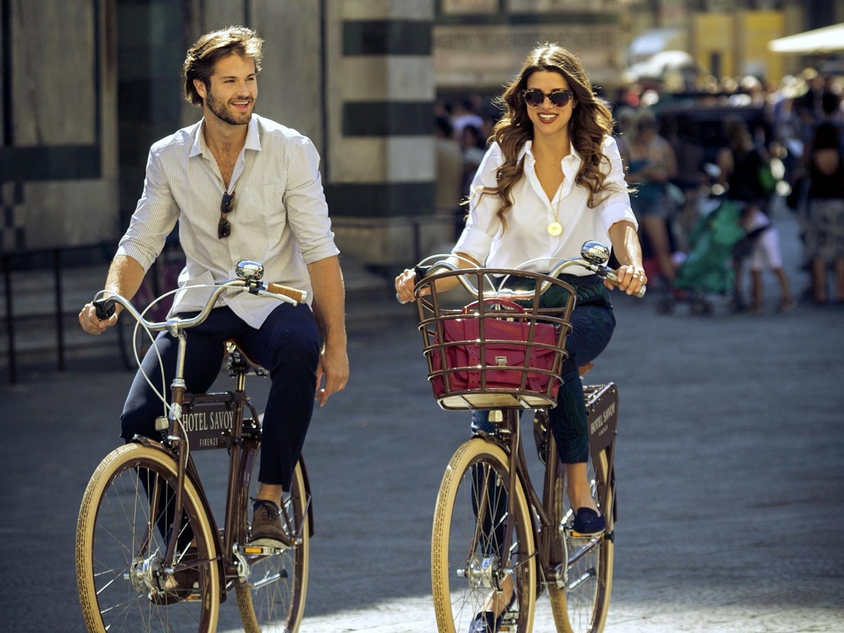 Two people cycling through the streets of Florence