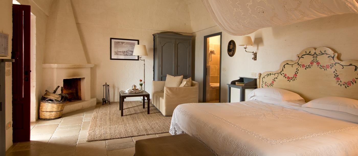 Junior Suite at luxury hotel Masseria Torre Coccaro in Italy with fireplace and seating area
