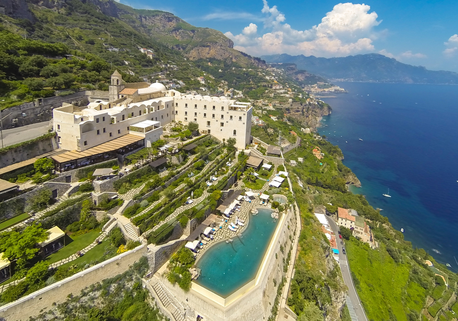 Aerial view of Monastera Santa Rosa, its pool and gardens overlooking the Mediterranean