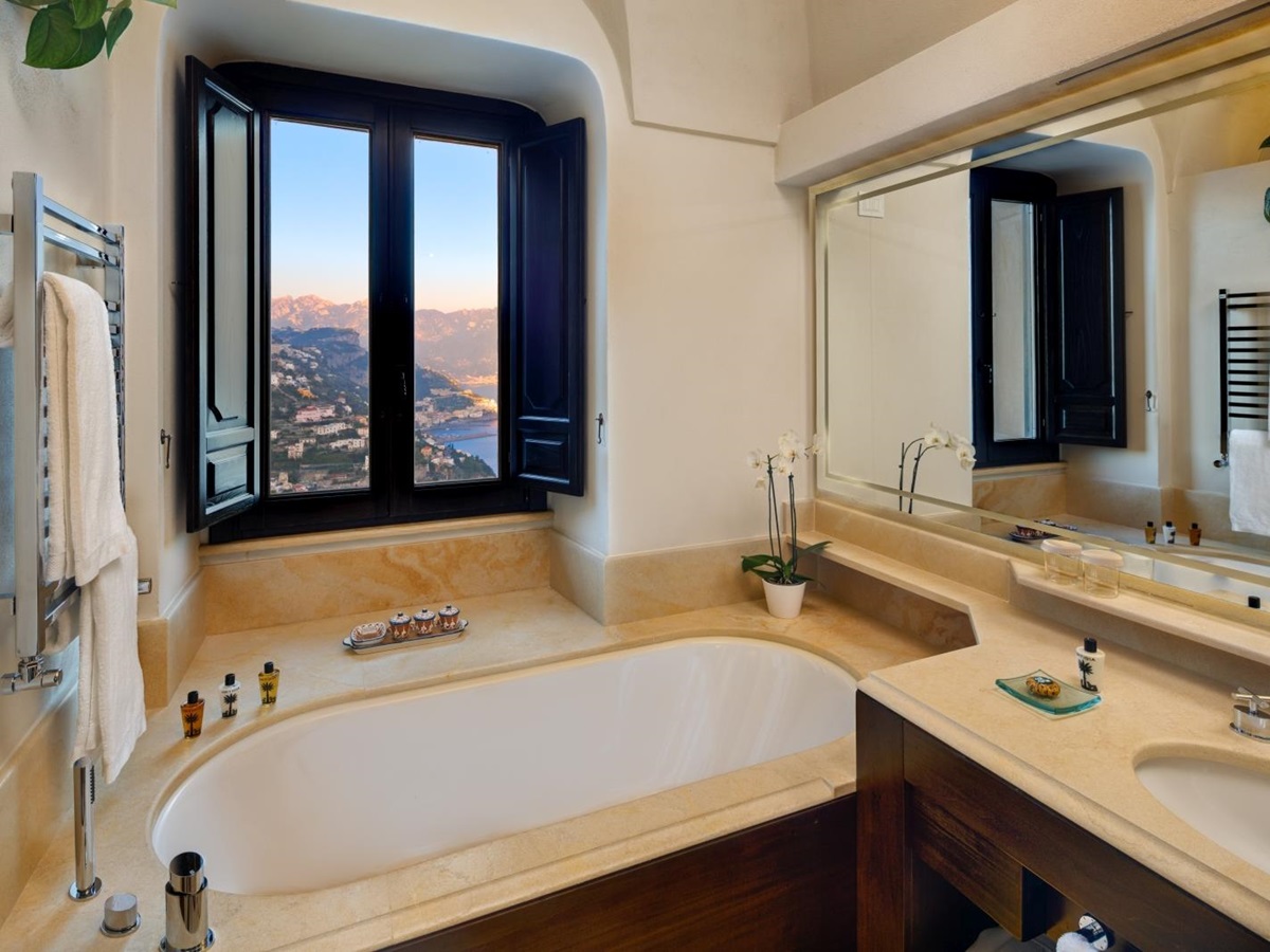 Bathroom with tub overlooking the surrounding hills and villages at Monastera Santa Rosa, luxury hotel in Italy