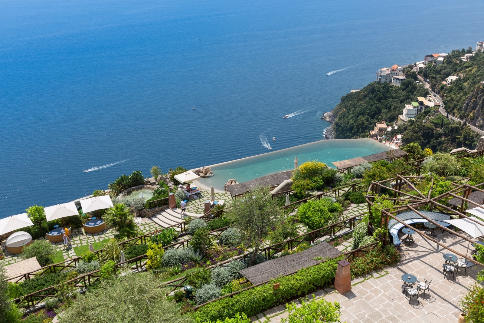 Overlooking the gardens and infinity pool down to the Mediterranean Sea at Monastera Santa Rosa, luxury hotel in Italy