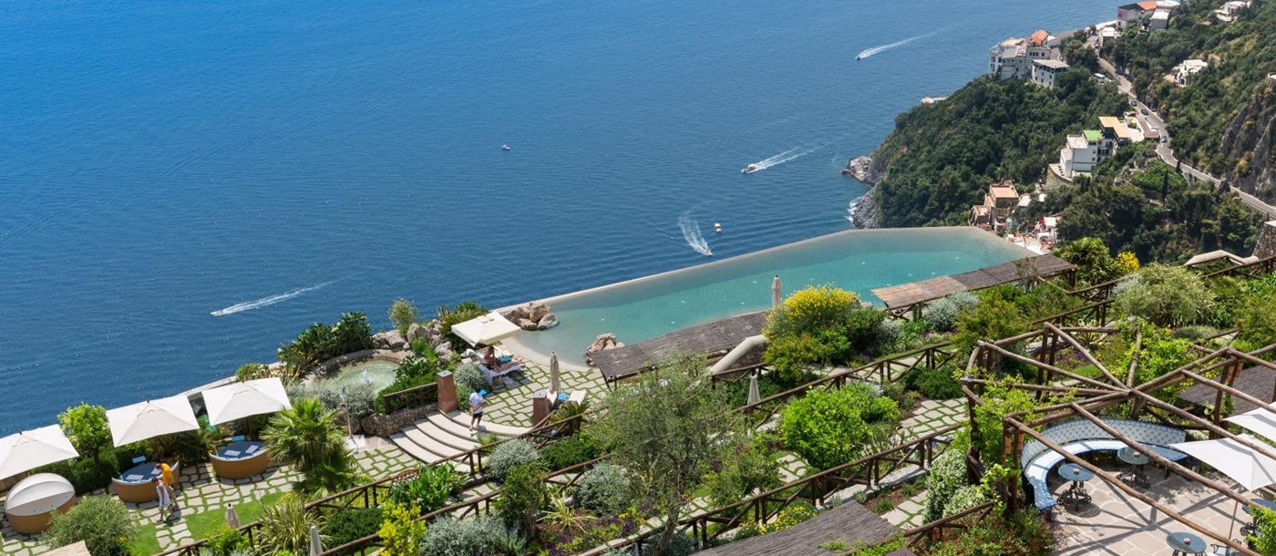 Overlooking the gardens and infinity pool down to the Mediterranean Sea at Monastera Santa Rosa, luxury hotel in Italy