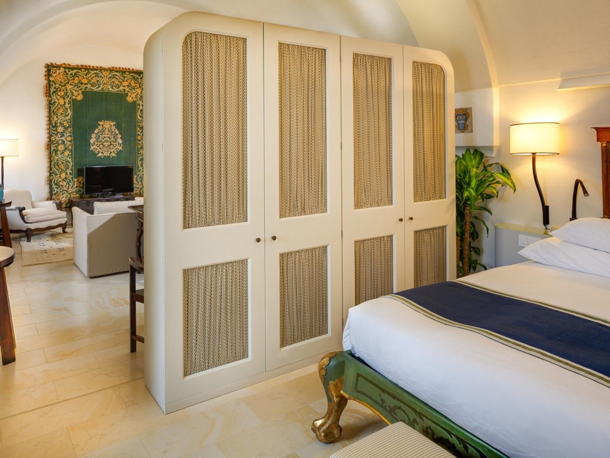 Junior Suite with private sitting area with an earthen toned colour palette at Monastera Santa Rosa, luxury hotel in Italy