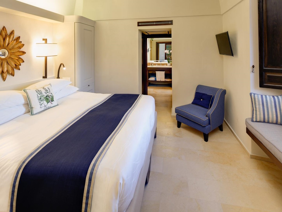 Double bedroom with wooden shutters at Monastera Santa Rosa, luxury hotel in Italy